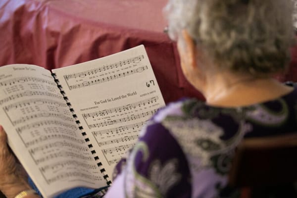 Senior resident reading sheet music at an activity session