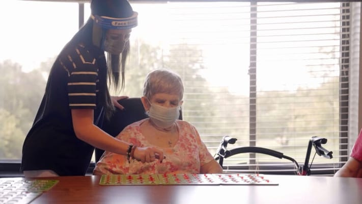 Staff assisting a resident during a bingo game