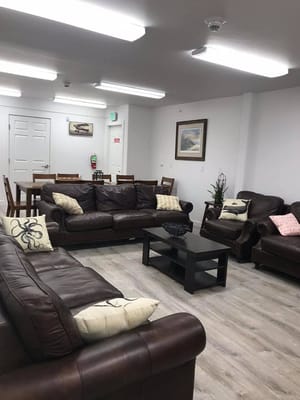 Common area with brown leather sofas and dining space