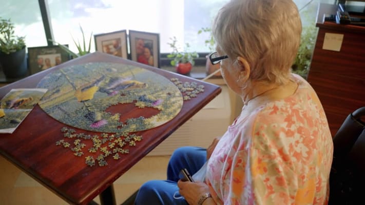 A resident working on a puzzle in a cozy room