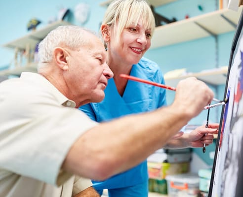 Resident and staff member engaged in an art activity