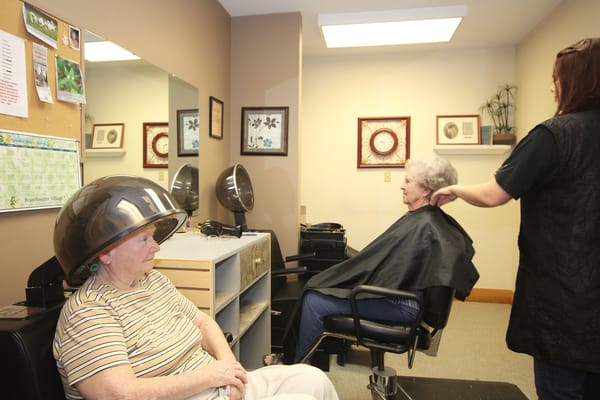 Residents receiving hair services in a salon area