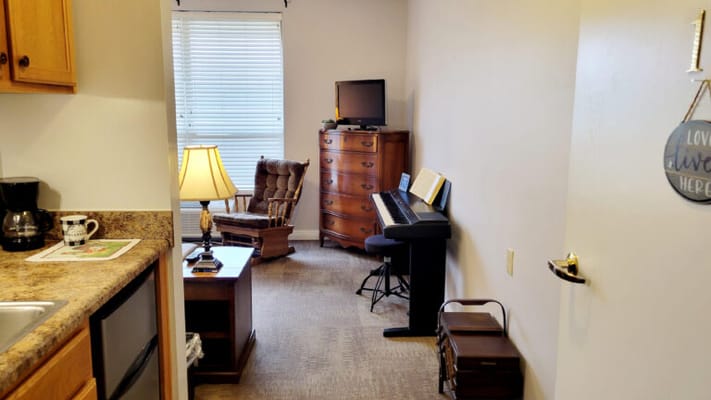 Cozy resident room with a piano and furniture