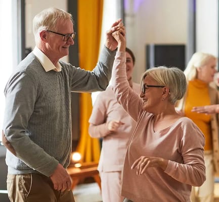 Residents dancing with staff at a social event