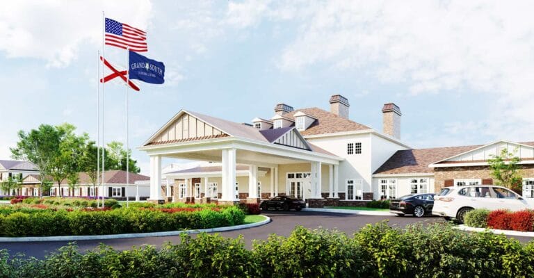 Front view of Grand South Senior Living with flags