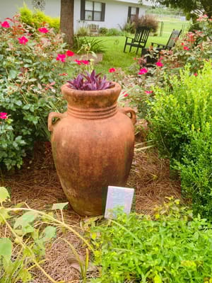 Decorative pot in a garden setting with flowers