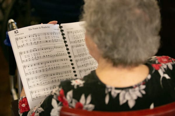 Senior resident reading music during a gathering