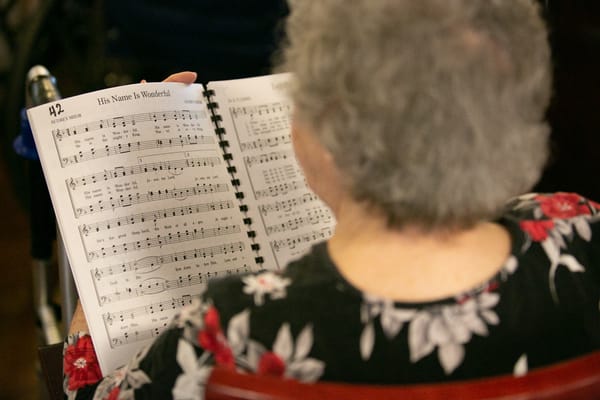 Senior resident reading music during a gathering