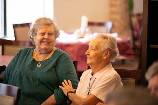 Two elderly residents enjoying a conversation in a common area