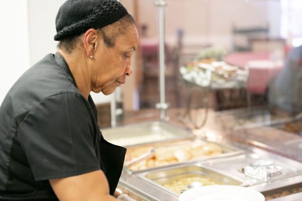 Staff member preparing food in a dining area