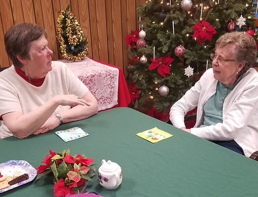Two residents enjoying conversation at a decorated table