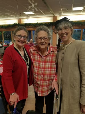 Three women in a festive common area.