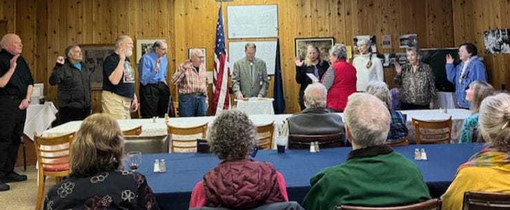 Residents and staff participating in a ceremony indoors