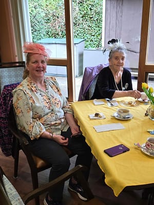 Residents enjoying tea with pastries at a dining table