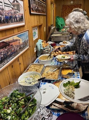Resident serving food at a community meal