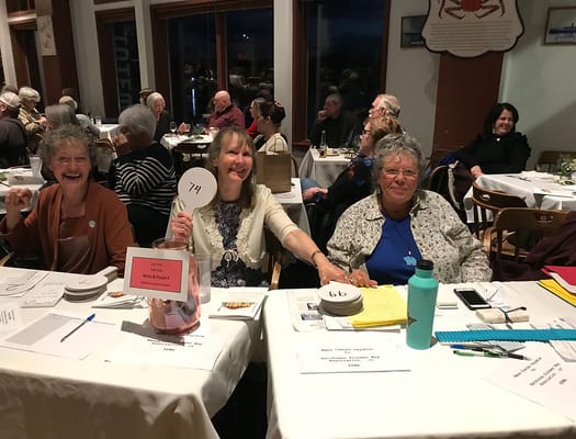 Residents enjoying an evening event, holding numbered signs