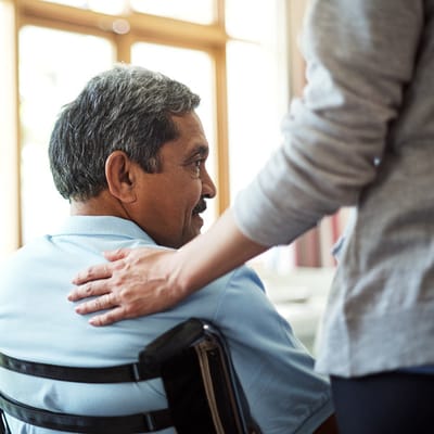 A caregiver assisting a resident in a common area
