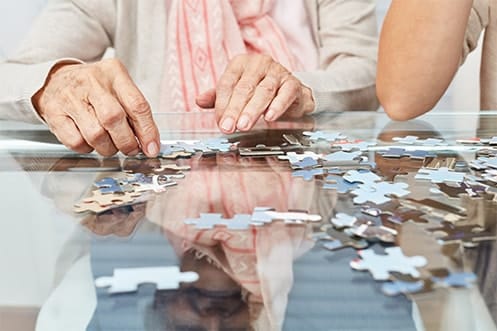 Residents working on a puzzle together at a table