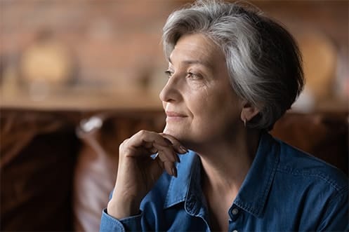 Senior woman thoughtfully seated in a cozy interior