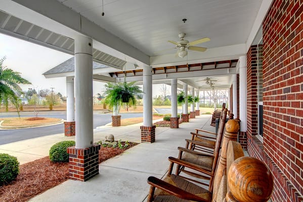 Covered porch area with rocking chairs and planters