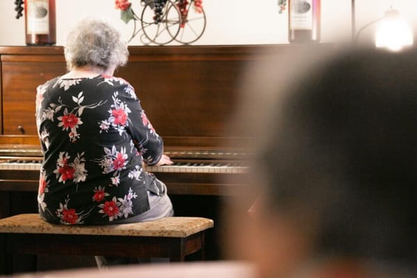 Resident playing piano in an activity room