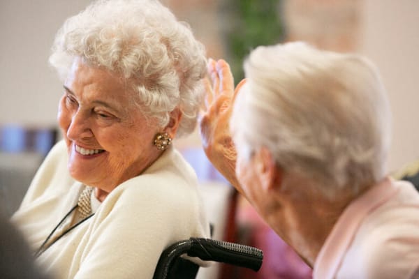 Two residents sharing a joyful moment in an interior setting
