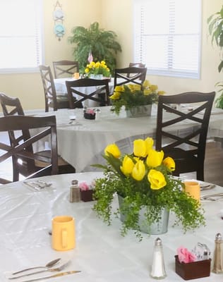 A bright dining room with yellow tulip centerpieces
