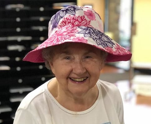 Elderly woman smiling in a colorful hat