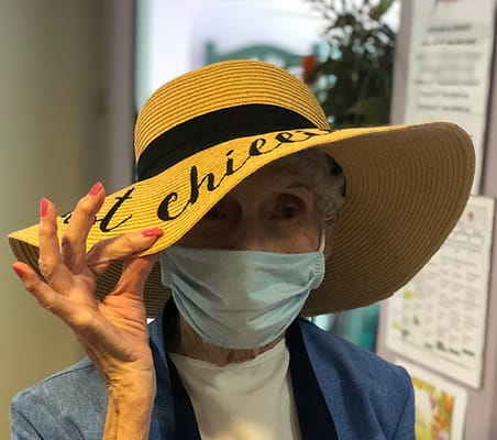 A resident wearing a large hat in a common area