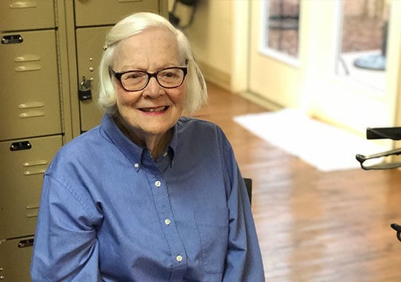 A senior woman smiling in a relaxed indoor setting