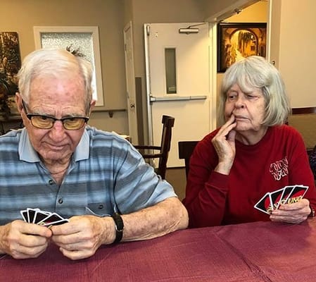 Residents engaged in a card game in a common area
