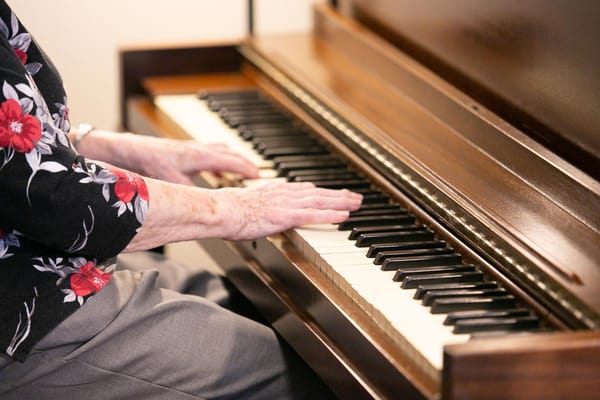 A resident playing the piano with floral shirt