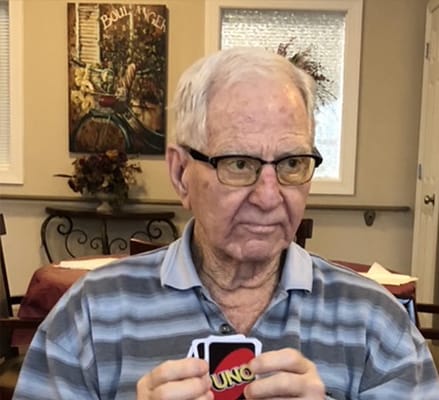 A senior man playing UNO in a common area