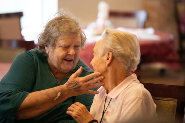 Two senior women engaged in a heartfelt conversation