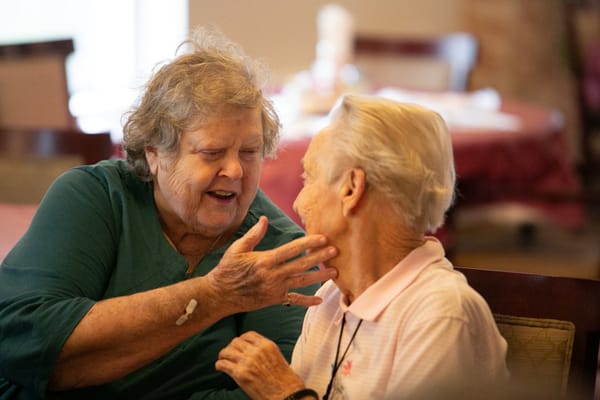 Two senior women engaged in a heartfelt conversation