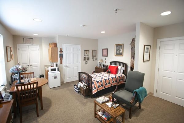 A private resident room with a bed and table