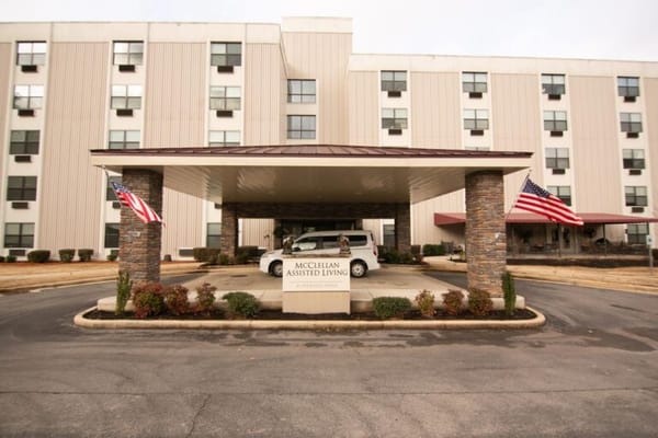 Exterior view of McClellan Assisted Living entrance with flags