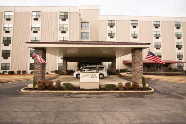 Exterior view of McClellan Assisted Living entrance with flags