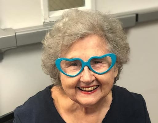 Senior woman smiling with playful heart-shaped glasses