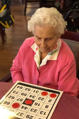 Resident playing bingo in a cozy activity room