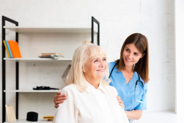 Nurse attending to a smiling senior woman in a bright room
