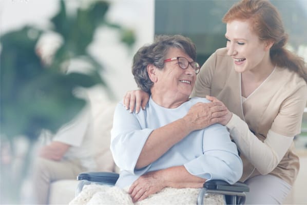 A caregiver and resident sharing a joyful moment indoors