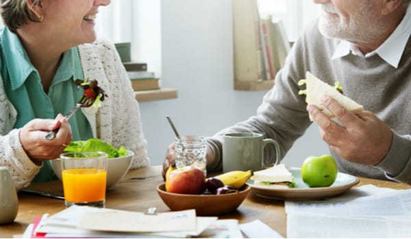 Two seniors enjoying a meal together at a table