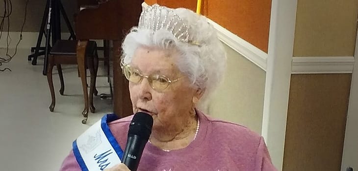 Resident participating in a pageant event with a microphone