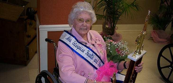 Resident crowned in a celebration with trophy and flowers