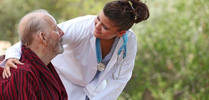 Nurse interacting with an elderly resident outdoors
