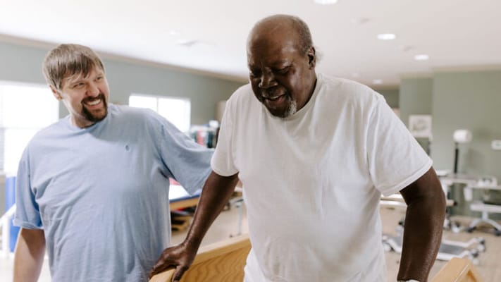 Staff assisting a resident in a rehabilitation setting