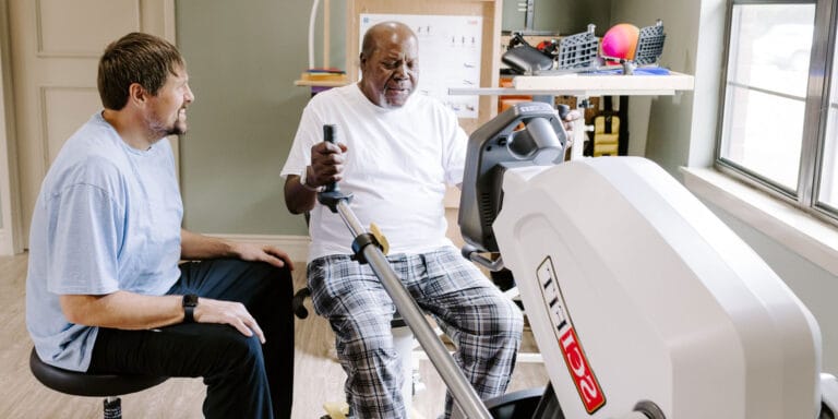 A therapist assisting a resident with a rehabilitation exercise