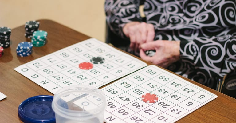 Residents playing bingo at a table with chips