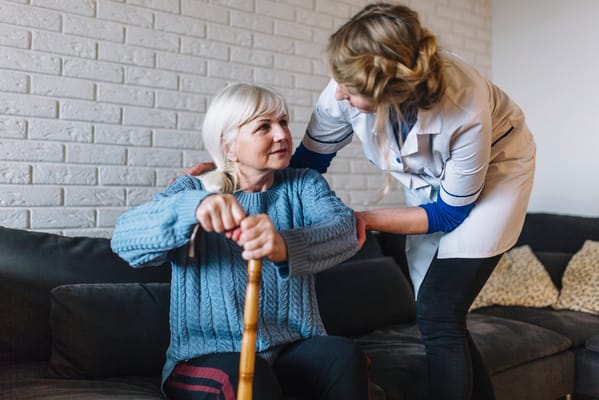 Caregiver assisting a resident in a cozy living room